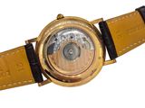 a gold watch with a brown leather strap on a white background