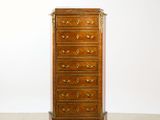 an antique chest of drawers on a carpeted floor in front of a white wall