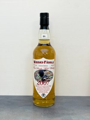 une bouteille de whisky posée sur une table à côté d'une bouteille de vin