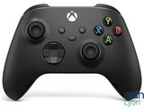 a close up of a black xbox controller on a white surface