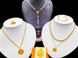 trois colliers et un collier avec une croix sur un support