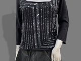 a mannequin wearing a black dress with silver sequins on it