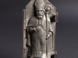 an old silver figurine of a man with a crown on his head