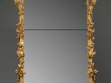 un miroir richement sculpté, avec un cadre doré sur fond gris