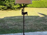 une lampe posée sur un trépied dans le jardin