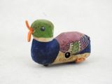 un petit oiseau en peluche posé sur une surface blanche