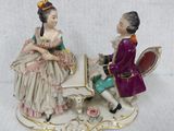 a figurine of a man and a woman sitting at a table