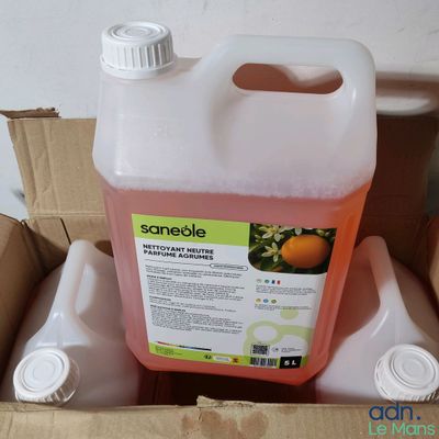 un bidon de jus d'orange posé dans une boîte en carton