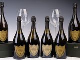 six bouteilles de champagne sont alignées à côté d'un verre à vin