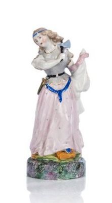 une figurine représentant une femme en robe rose tenant un oiseau