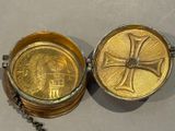 a gold locke with a cross on it sitting on a table