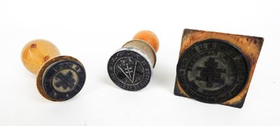 trois cachets en cire sur lesquels figurent un tampon et un autre tampon
