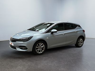 a silver opel parked in a white room with a black floor