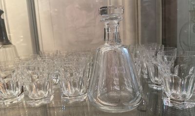many glasses and a decanter sitting on a table