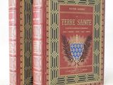 two red books sitting on top of each other on a white surface