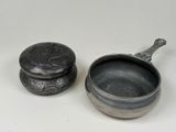 pair of silverplated bowls with lids and spoons on a white surface