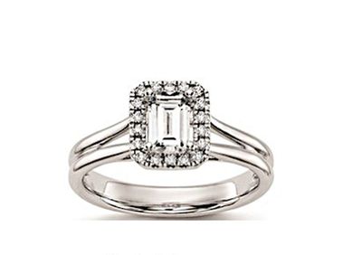 une bague de fiançailles en or blanc sertie d'une émeraude entourée de diamants