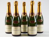 four bottles of champagne are lined up in a row