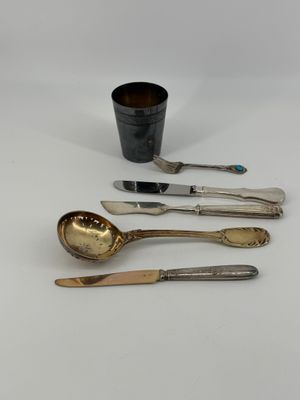 three spoons and a cup are sitting on a table