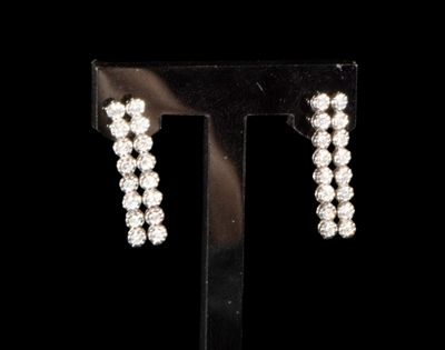 a close up of a pair of earrings on a stand