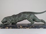 statue of a running leopard on a marble base