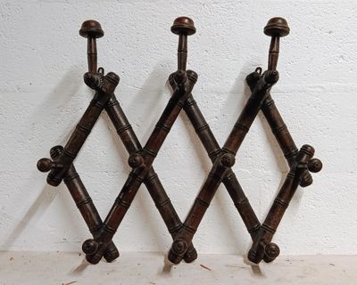 three metal hooks on a white wall with a white wall behind them