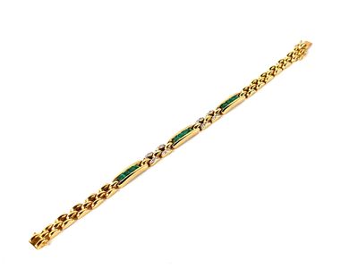 un gros plan d'un bracelet en or orné d'une pierre verte