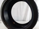 a close up of a tire on a white surface with a white curtain in the background