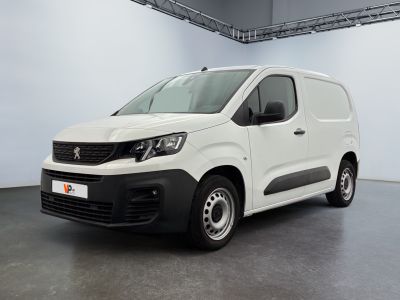 La camionnette blanche est garée dans une grande pièce.