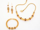 an image of a gold necklace and bracelet set on a white background