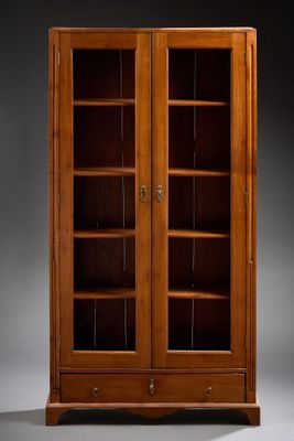 une grande bibliothèque en bois avec des portes vitrées et des étagères