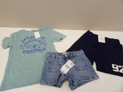 two pairs of shorts and a t - shirt are on a table