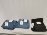 three pairs of men ' s jeans sitting on a white table