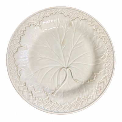 une assiette blanche ornée d'une feuille sur fond blanc
