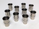 six verres à shot en acier inoxydable posés sur une surface blanche