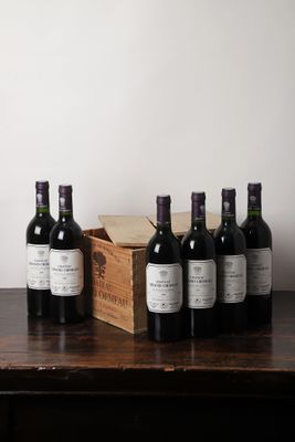 plusieurs bouteilles de vin posées sur une table à côté d'une caisse en bois