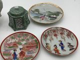 four plates and a vase on a white table