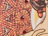 an image of a close up of a woman ' s face with red beads on it