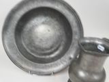 two silver vases and a silver plate on a table