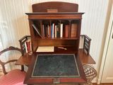 a desk with a chair and a book shelf in the corner