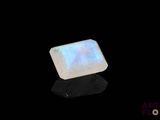 a white oplite stone on a black surface
