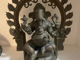 a bronze statue of a woman sitting on a chair