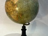 an old globe on a black stand with a white background