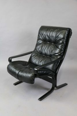 a black leather recliner chair with a black metal frame