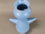 a small blue vase with a bird on it