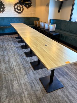 une longue table au milieu d'une pièce avec des canapés bleus
