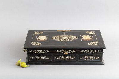 une boîte noire et dorée posée sur une table blanche
