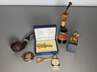 a box with a pipe, a watch, a pipe holder, a watch and a pipe