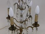 un petit lustre en cristal à trois lumières