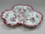 a red and white plate with a flower design on it